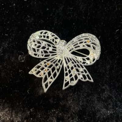 Filigree Bow Brooch in Silver Tones. Missing some stones.