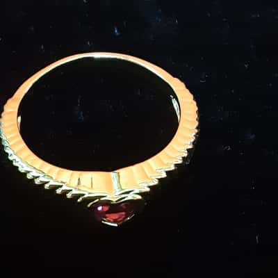 Ladies Gold Tone textured band featuring a heart-shaped Red stone