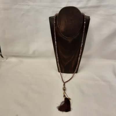 Long strand of purplish tone crystal and glass prayer beads finished with the decorative pattern marker bead and maroon tassel