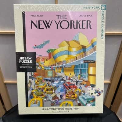 New With Tags 1000 Pieces New York Puzzle Company Jigsaw Puzzle 48.9 cm X 67.6 cm J. F. K. INTERNATIONAL ROCKETPORT Cover by Bruce McCall RRP from different shop: $39.99- $50.00