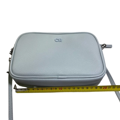 Country Road Tonal Camera Bag or a variation of their Branded/Contrast Camera Bag series. It is made with a textured Saffiano polyurethane finish and features the iconic powder-coated "CR" monogram hardware centered on the front. 21 x 14 x 4cm