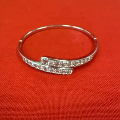  Women's Silver Tone Hinged Bypass Bangle featuring a Pave Setting of CZ Stones aAlong the Overlapping Ends