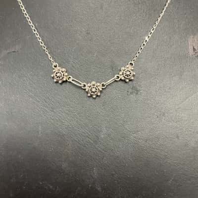  Womens Sterling silver necklace with three decorative flower shaped pendants.