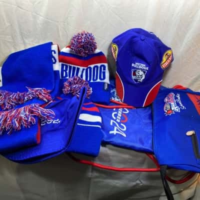 collection of Western Bulldogs AFL supporter merchandise including a cap, backpacks, beanies, and a scarf
