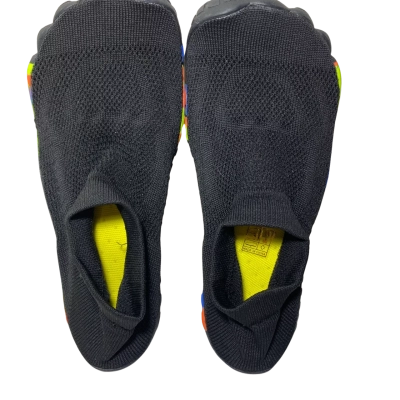 A pair of black slip-on minimalist toe-pocket or barefoot knit shoes with bright yellow inner insoles and colorful multi-accent soles