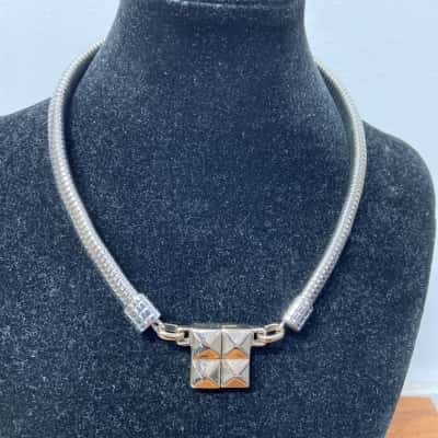 Silver toned necklace with tubular chain and a square studded pendant 