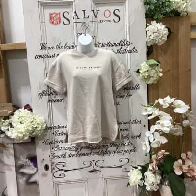 D-Luxe Brand! NWOT! DESIGNED IN AUSTRALIA! FRONT PANEL FEATURES BOLD SCRIPT LOGO "D-LUXE. EST. 2016" Women's  Size XXS Short Sleeve Shirt / Short Sleeve Top / T-shirts Beige / Nude 