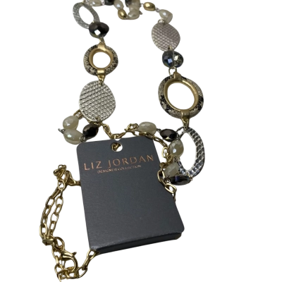 Liz Jordan Womens two-tone silver and gold metal statement necklace featuring mixed geometric links, textured discs, and beaded accents resting on a card.
