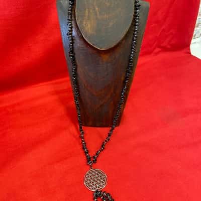  Ladies long beaded necklace featuring a silver tone geometric pendant  