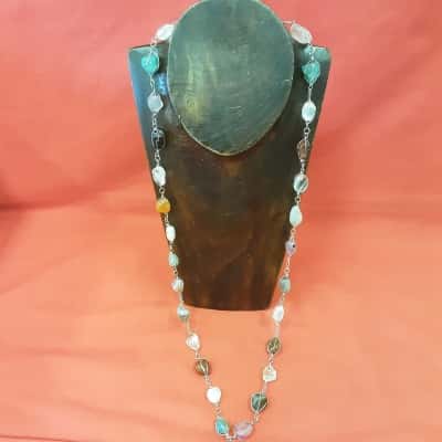 Long fine silver tone wire woven around multi colored gemstones