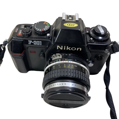 Nikon F-301 35mm SLR film camera with a detachable lens, featuring an integrated motor drive that advances film at 2.5 frames per second