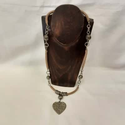 Ornate textured Silvertone heart pendant hanging from cord and metal bead necklace
