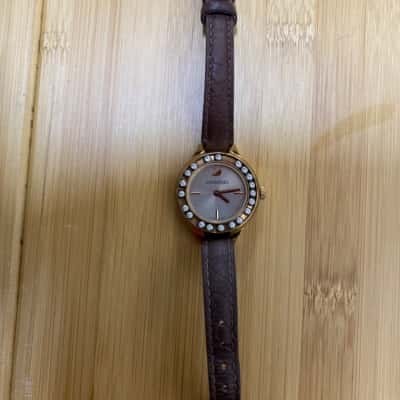 Swarovski Womens Gold and leather strapped watch