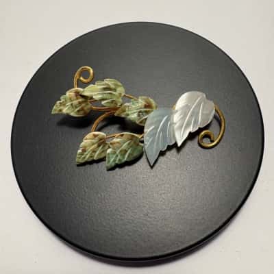   Vtg. Brooch featuring white mother of pearl leaves set on a gold-toned stem