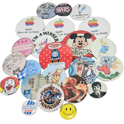 A bundle of 23 badges. Retro Australian, English and Americana pop culture iconography.