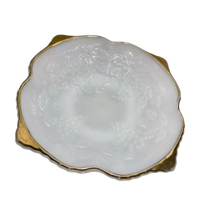 a vintage Anchor Hocking white milk glass square serving bowl featuring an embossed grape and vine pattern with bright gold trim accents on the scalloped corners.
