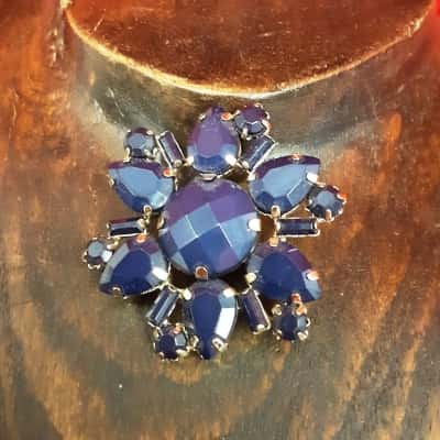 Vintage style Gold Tone floral brooch featuring faceted deep blue stones