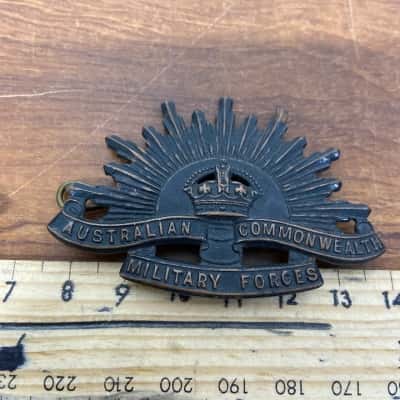 Pair of brass Rising Sun hat badges 