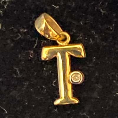  Women's 9K Gold Pendant/Charm as a "T" with tiny stone on side.