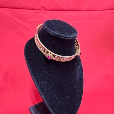  Womens Gold tone Bangle featuring multiple rows of rhinestones adorned with red stones 