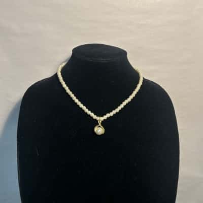 Faux pearl necklace with gold tone pendant 