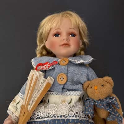 Collectible porcelain doll,with porcelain head, hands, and feet, with a soft cloth body.The doll has a broken leg, which can be fixed, and is missing a hat.(B12)