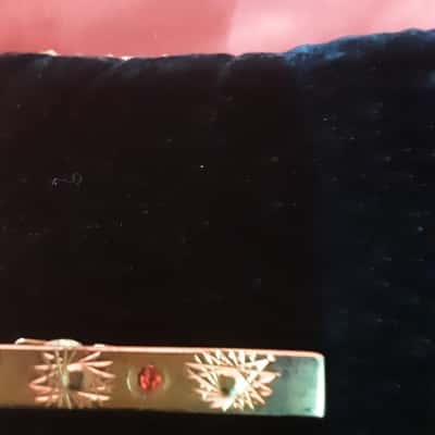 Men's Gold Tone Tie bar featuring etched work  and a red stone