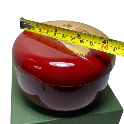 Japanese decorative lacquer-style container featuring a red base and gold leaf accent with a cherry blossom (sakura) design on the lid, resembling the Hakuichi Red Cherry Blossom Bonbon