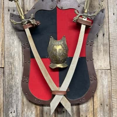 Decorative wall plaque featuring crossed swords and a shield 