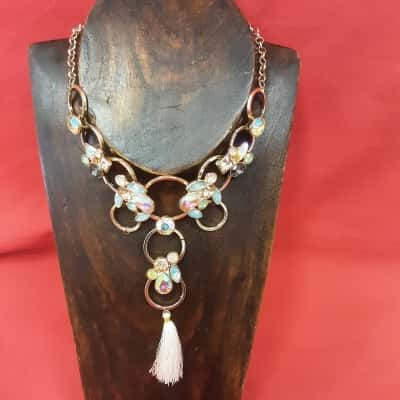 Gold Tone Statement necklace featuring a unique design of interlocking circles adorned with iridescent gems