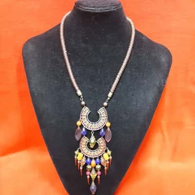 Bohemian style statement necklace featuring multicoloured beads metal spikes and decorative circular pendants