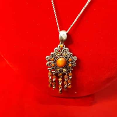 Ladies silver tone piligree pendant necklace featuring Coral style stones