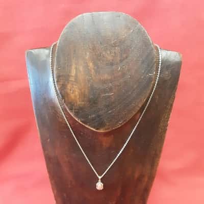 Vintage style pendant necklace featuring a metalo and floral design set with  pink cabochon