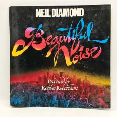 Neil Diamond – Beautiful Noise 12" Vinyl Album From 1976. Gatefold Sleeve Is In Very Good Condition. LP Some Text Markings On One Label & Has Some Scuffs & Light Scratches