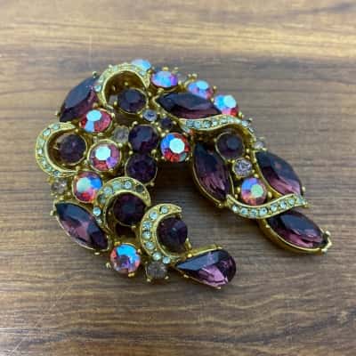 Vintage gold toned brooch encrusted with pink, violet, purple and clear stones